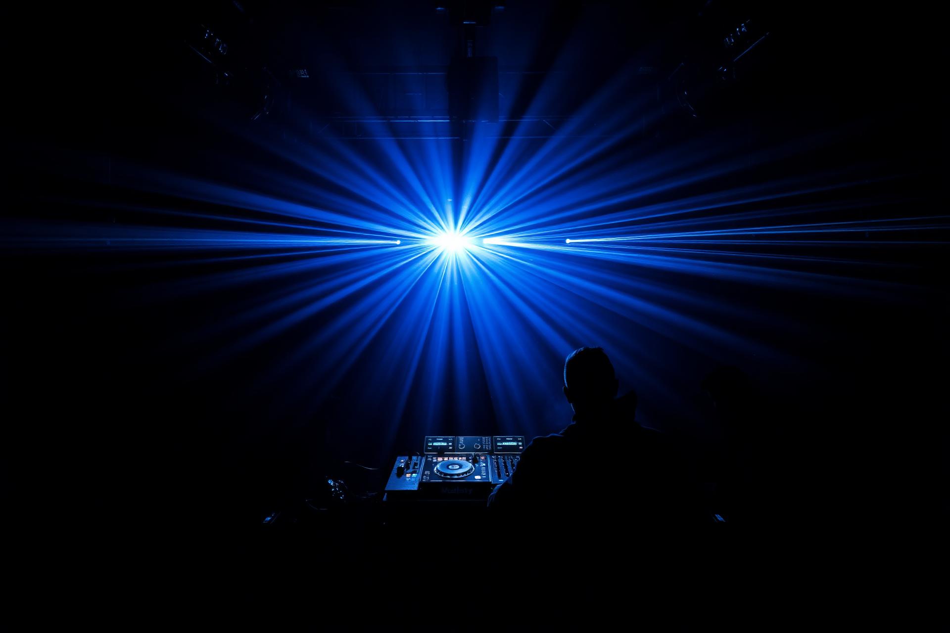 DJ tocando com iluminação de palco azul
